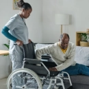 Caregiver helping senior man with wheelchair