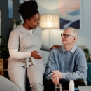 Caregiver talking with senior man at home