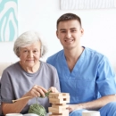 Caregiver playing blocks with elderly woman