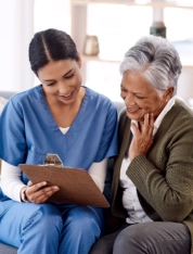Caregiver reviewing notes with elderly woman