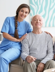 Caregiver smiling beside an elderly man