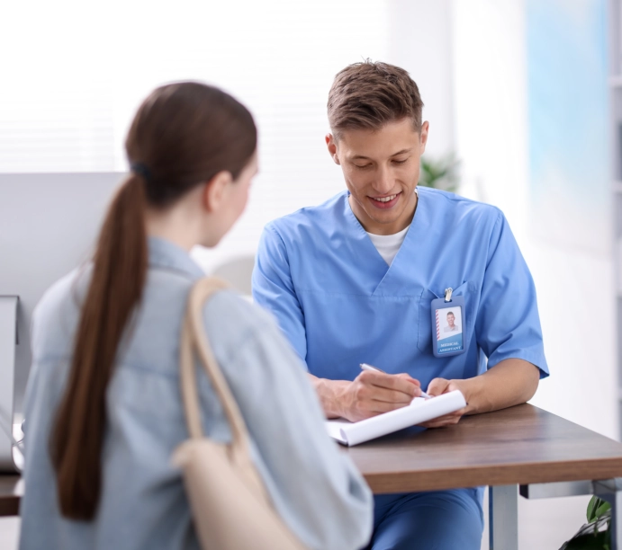 Male nurse writing notes during client consultation