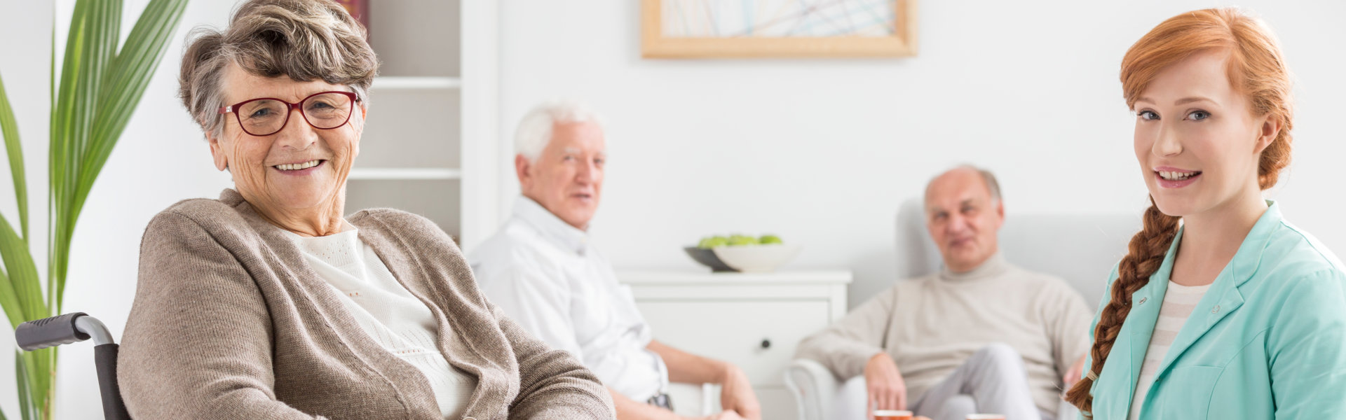 Caregiver smiling with seniors in a living room