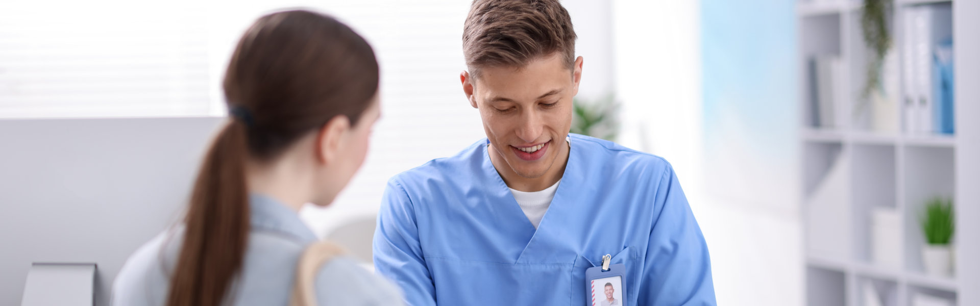 Male nurse writing notes during client consultation
