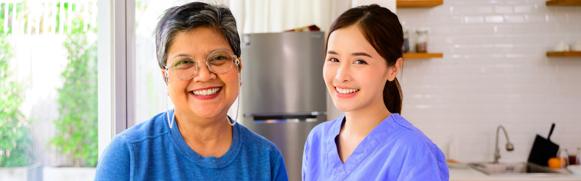 Elderly woman and caregiver smiling